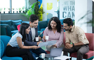  Four professionals collaborating in a modern office lounge.